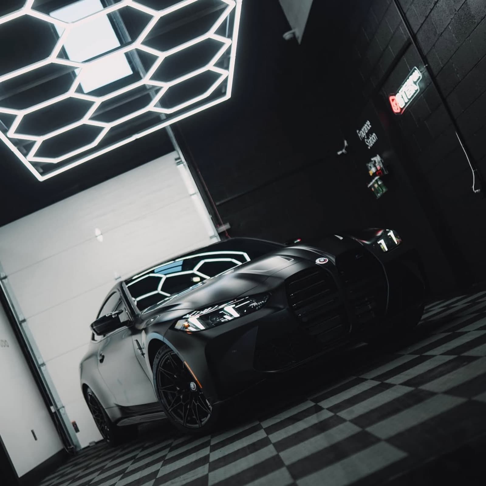 Black BMW M4 under detailing lighting after a full correction and coating