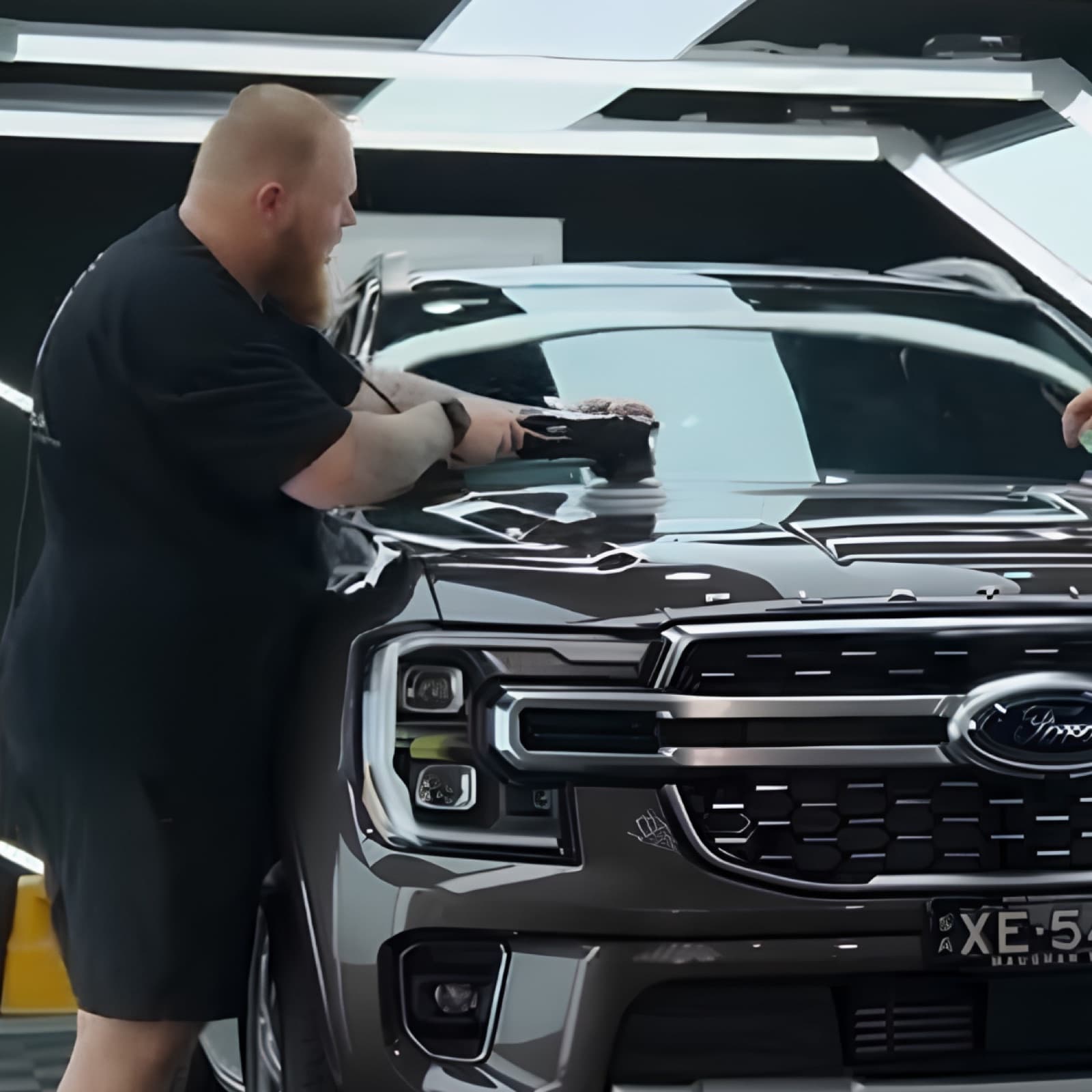 Machine polishing the bonnet of a Ford SUV during paint correction